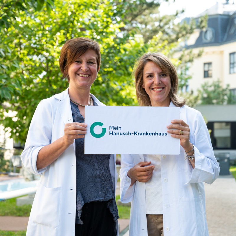 Elisabeth Zwettler und Valerie Nell-Duxneuner halten ein Schild mit der Aufschrift "Mein Hanusch-Krankenhaus"