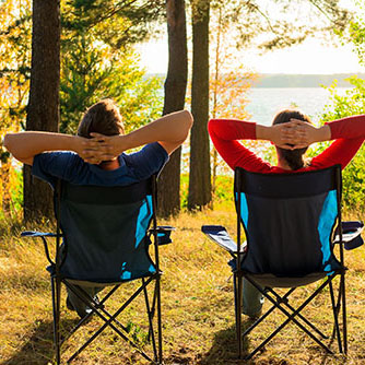 Zwei Personen im Campingsessel blicken auf einen See_Bildquelle: kosmos111/shutterstock.com