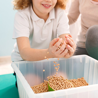 Kind nimmt eine Handvoll Kerne aus einer Box