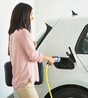 Eine Frau lädt ein Elektrofahrzeug auf, Foto: husjur02/Shutterstock.com